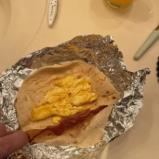 a hand holding a burrito