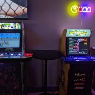 TMNT arcade 1up machine next to a machine featuring 20,000 different games.