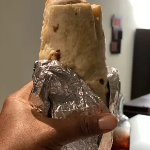 a hand holding a burrito