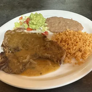 Delicious steak ranchero with rice, beans, salad and guacamole