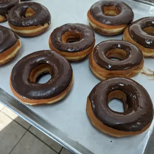 a tray of chocolate covered doughnuts