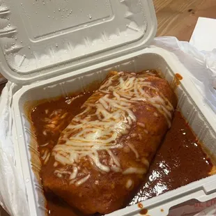 Wet shrimp burrito with red sauce.
