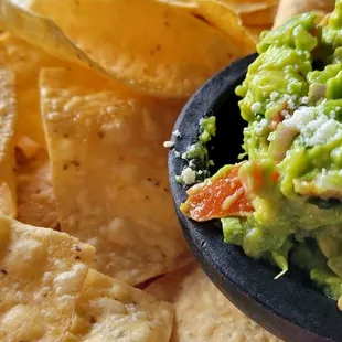 a bowl of guacamole and tortillas