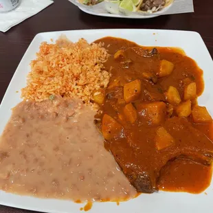 Guisado with pork chops in a red sauce.