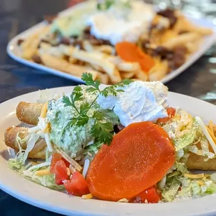 Chicken flautas con todo, carne asada fries in the background.