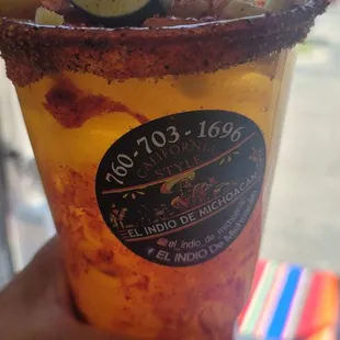 a hand holding a cup with a drink in it