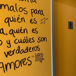 a yellow wall with writing on it