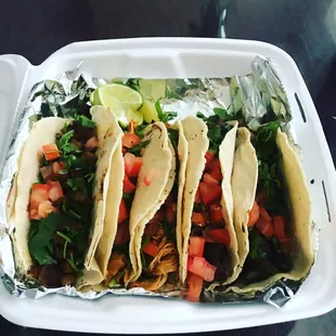 three tacos in a styrofoam container