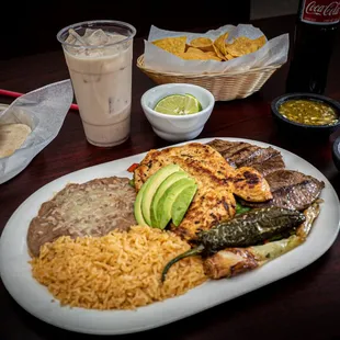 El Dos Amigos: Carne Asada Steak and Chicken Breast on top of a bed of grilled vegetables. Served with rice, beans and tortillas