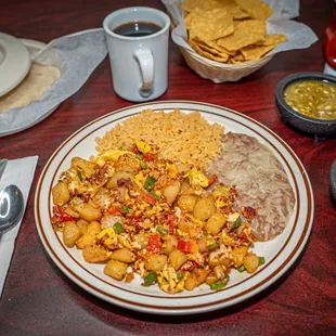 Scrambled eggs with chorizo, potatoes, bell peppers, onions. Served with a side of rice, beans and tortillas