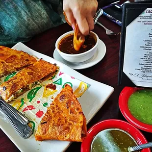 a plate of quesadillas and a bowl of salsa
