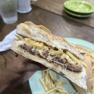 a hand holding a sandwich