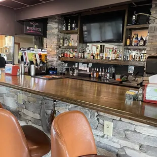 a bar with brown leather chairs