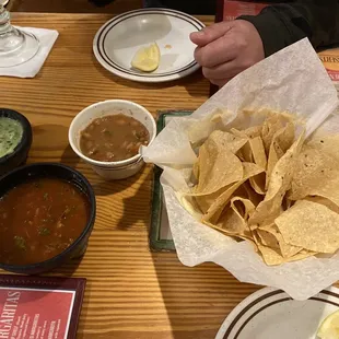 Warm salsa green sauce and beans with homemade chips