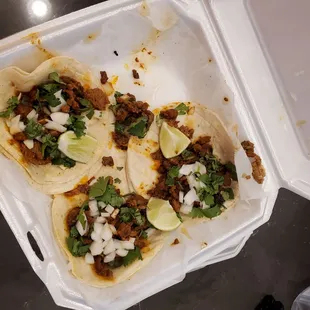 three tacos in a styrofoam container
