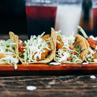 three tacos on a wooden plate