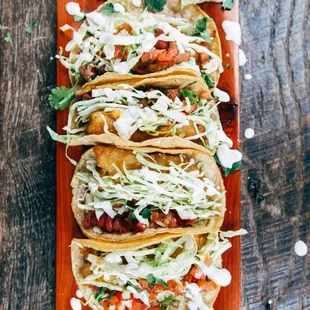 a plate of fish tacos on a wooden table