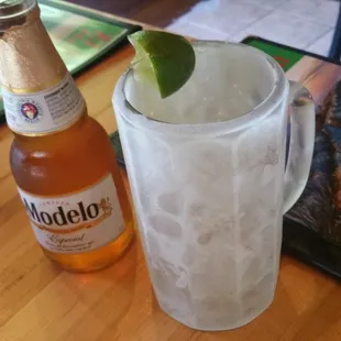 a glass of ice and a bottle of beer