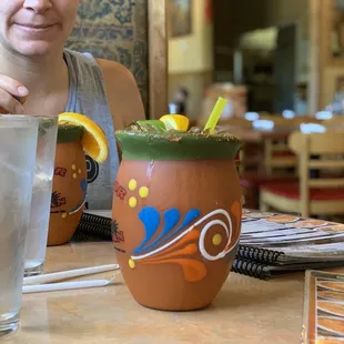 a woman sitting at a table with a drink