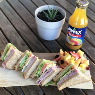 Club sandwich with avocado and fruit salad