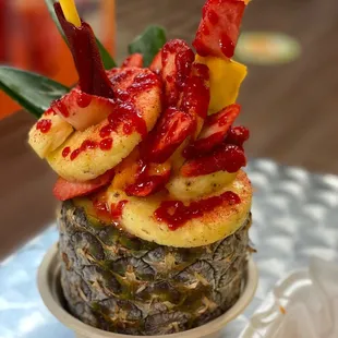 a pineapple topped with fruit