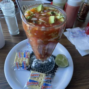 a bowl of salsa and crackers on a plate