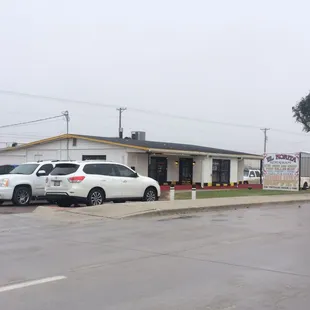 a white car parked in front of a restaurant