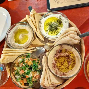 a plate of food with pita chips and dips