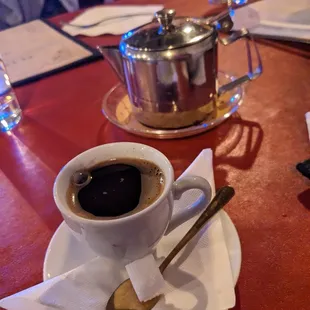 a cup of coffee and a spoon on a table