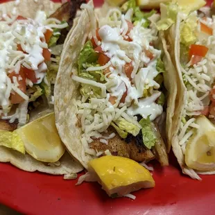 three fish tacos on a red plate