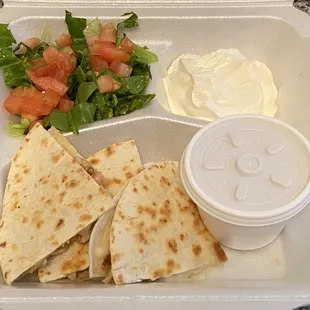 Grilled chicken quesadillas with sour cream, hot sauce and the lettuce and diced tomatoes on the side.