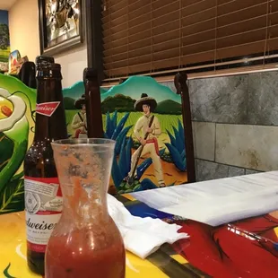 a glass of hot sauce and a bottle of hot sauce