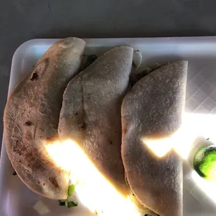 three flatbreads on a white plate