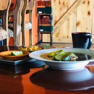 a bowl of soup and a plate of pickles