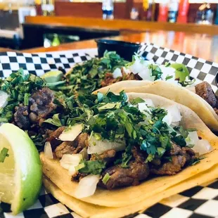 three tacos on a checkered plate