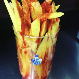 a glass of fries with ketchup and ketchup