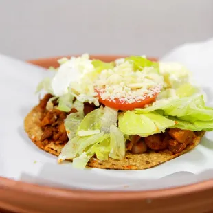 a taco with lettuce and tomato