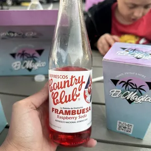 a person holding a bottle of fruit juice