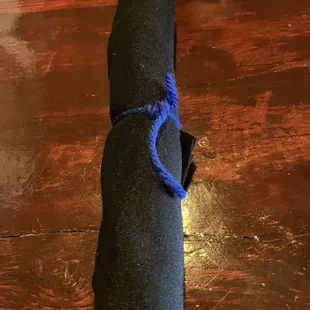 a roll of black fabric on a wooden table