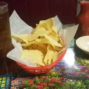 a bowl of chips and a drink