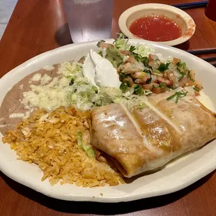 This is a chicken chimichanga with Mexi rice, refried beans, extra sour cream and some veggies.