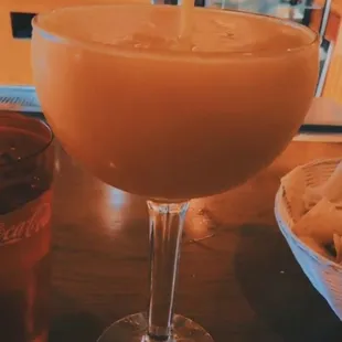 a glass of orange juice and a plate of chips