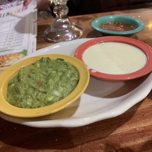 two bowls of guacamole and a drink