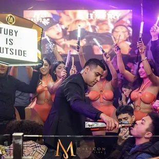 a man in a tuxedo cutting a cake