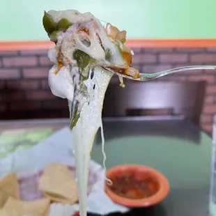 a close up of a piece of pizza on a fork