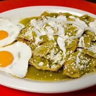 a plate of enchiladas with two fried eggs