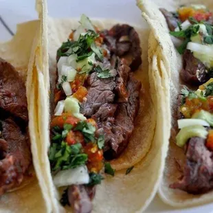 three beef tacos on a plate