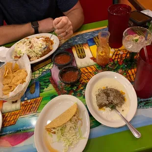a man sitting at a table with plates of food