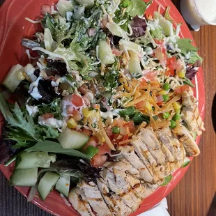 a red plate with a salad on it