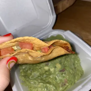 Chicken corn shell crunchy taco. Guacamole in background